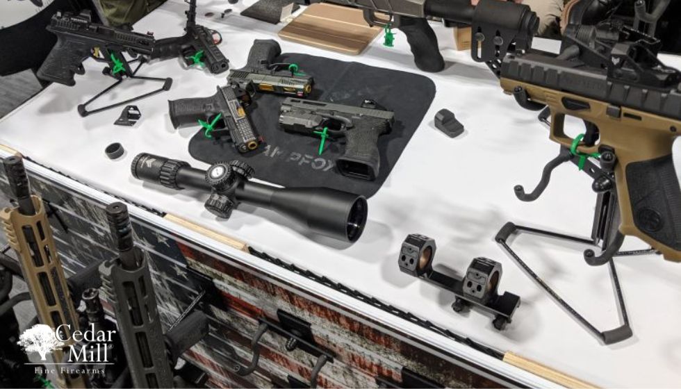 A table displaying various guns and related items arranged neatly on its surface.