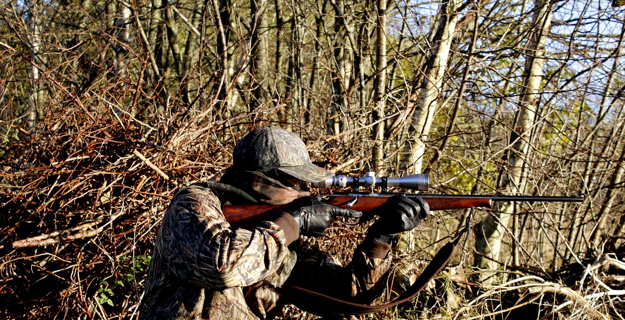 A hunter aiming a hunting rifle