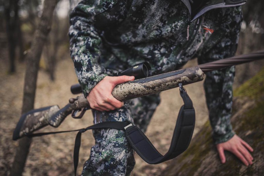 A hunter carrying their Savage 110 Hunter as they scale the hunting trail